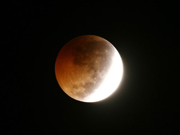 เริ่มเห็นจันทร์เป็นสีแดงอิฐ (ภาพจาก นายพรชัย อมรศรีจิรทร/สมาคมดาราศาสตร์ไทย)
