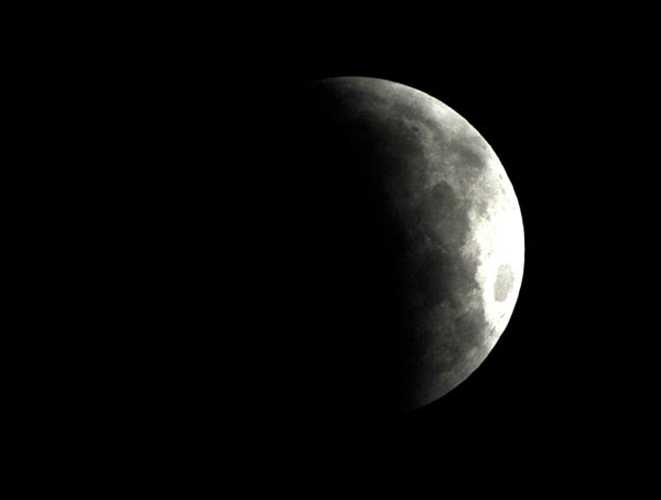 เงาโลกค่อยๆ พาดลงบนพื้นผิวดวงจันทร์ทีละน้อยๆ บันทึกโดย Farooq NAEEM (ภาพจาก AFP)