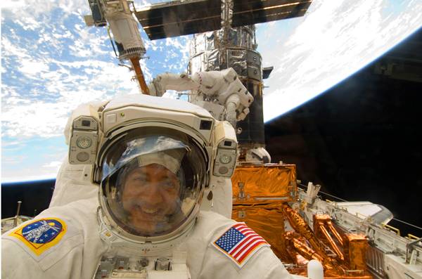 ไมค์ มาสซิมิโน ผู้เชี่ยวชาญประจำภารกิจของเที่ยวบินที่ STS-125 มองผ่านเข้ามาในแอนแลนติสเพื่อให้เพื่อนนักบินบันทึกภาพที่มีฮับเบิลและโลกและฉากหลัง ระหว่างภารกิจยืดชีวิตให้ฮับเบิล (AFP PHOTO/NASA VIDEO)