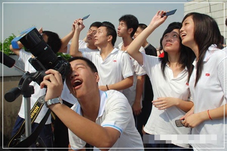 นักเรียนโรงเรียนมัธยมแห่งหนึ่งในเมืองเฉวียนโจว มณฑลฝูเจี้ยน ยืนชมปรากฏการณ์สุริยุปราคาบนดาดฟ้าของโรงเรียน