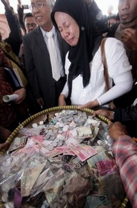 Indonesian Prita Mulyasari cries as she receives money donated by Indonesians across the country, in Tangerang, on December 9. From Aceh to Bali, people have been donating a truckload of coins to help the woman who became a cause celebre after being jailed for sending a controversial defamation email. (AFP/File/Nurani Nuutong) 