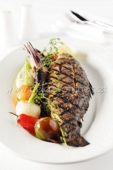ปลากระพงสายพันธุ์ฝรั่งเศสอบเสิร์ฟพร้อมกับผักและมะนาว