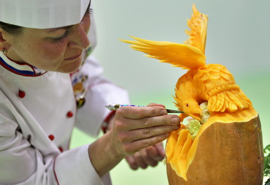 Leipzig, Saxony, GERMANY: Russian vegetable carver Anastasia Korsakova makes finishing touches on her work on September 5, 2011 during the first European carving competition in Leipzig, eastern Germany. The competition is taking place during the Gaeste trade fair for the restaurant, hotel and catering business running until September 6, 2011. Within four hours, competitors have to carve in front of the jurys eyes a piece from melons, papayas, stem cabbage, cucumbers, radish, carrots and Chinese cabbage. AFP PHOTO/Jan Woitas 