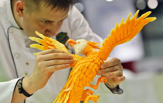 Leipzig, Saxony, GERMANY: Russian vegetable carver Vadim Nefedjev makes finishing touches on his eagle work on September 5, 2011 during the first European carving competition in Leipzig, eastern Germany. The competition is taking place during the Gaeste trade fair for the restaurant, hotel and catering business running until September 6, 2011. Within four hours, competitors have to carve in front of the jurys eyes a piece from melons, papayas, stem cabbage, cucumbers, radish, carrots and Chinese cabbage. AFP PHOTO/Jan Woitas