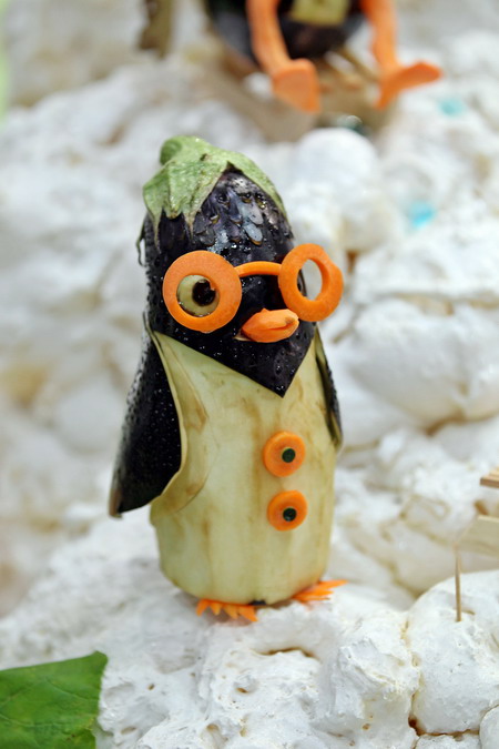 Leipzig, Saxony, GERMANY: A penguin made from an aubergine and carrots is on display on September 5, 2011 during the first European vegetable carving competition in Leipzig, eastern Germany. The competition is taking place during the Gaeste trade fair for the restaurant, hotel and catering business running until September 6, 2011. Within four hours, competitors have to carve in front of the jurys eyes a piece from melons, papayas, stem cabbage, cucumbers, radish, carrots and Chinese cabbage. AFP PHOTO/Jan Woitas 