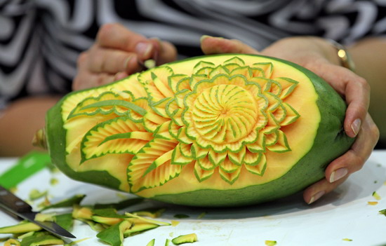 Leipzig, Saxony, GERMANY: A woman carves a mango on September 5, 2011 during the first European vegetable carving competition in Leipzig, eastern Germany. The competition is taking place during the Gaeste trade fair for the restaurant, hotel and catering business running until September 6, 2011. Within four hours, competitors have to carve in front of the jurys eyes a piece from melons, papayas, stem cabbage, cucumbers, radish, carrots and Chinese cabbage. AFP PHOTO/Jan Woitas 