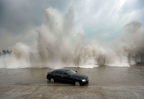 Qingdao, Shandong, CHINA: This picture taken on August 28, 2012, shows a car surrounded by water after its owner parked it on the bank to watch waves brought on by Typhoon Bolaven in Qingdao, in northeast Chinas Shandong province. Typhoon Bolaven -- the strongest storm to hit South Korea for almost a decade -- left a trail of death and damage in southwestern and south-central regions of the Korean peninsula on August 28, and crossed into China early on August 29. AFP PHOTO