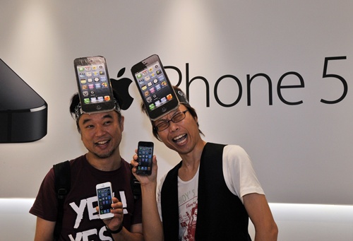 Tokyo, Tokyo, JAPAN: Customers react after purchasing Apples new iPhone 5 smartphone at the Softbank mobile phone shop in Tokyo on September 21, 2012. The iPhone 5 goes on sale on September 21 in Singapore, Sydney, US, Canada, France, Germany, Hong Kong, Japan and Britain. AFP PHOTO/Yoshikazu Tsuno