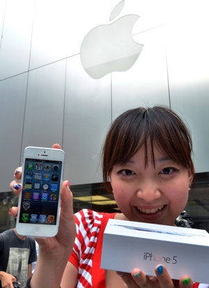 Tokyo, Tokyo, JAPAN: A customer reacts after purchasing Apples new iPhone 5 smartphone at the Softbank mobile phone shop in Tokyo on September 21, 2012. The iPhone 5 goes on sale on September 21 in Singapore, Sydney, US, Canada, France, Germany, Hong Kong, Japan and Britain. AFP PHOTO/Yoshikazu Tsuno