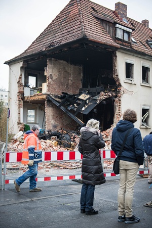 Schweinfurt, Bavaria, GERMANY: People stand in front of a partly damaged house in Schweinfurt, southern Germany, on February 17, 2013. Unknown reason led to an explosion that harmed a man. AFP PHOTO/David Ebener 
