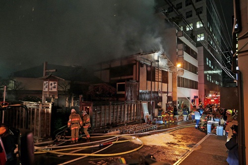 Tokyo, Tokyo, JAPAN: Smoke rises from an old establishment soba (Japanese noodle) restaurant Kanda Yabusoba in Tokyo on February 19, 2013. No one was injured but the 1880 established wooden made restaurant was burnt down. AFP PHOTO/Jiji Press 