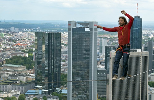 Frankfurt am Main, Hessen, GERMANY: Austrian slackliner Reinhard Kleindl balances on a cord between the two towers of the Tower 185as part of the skyscraper festival in Frankfurt am Main, western Germany, on May 25, 2013. The festival takes place from may 25-26, 2013 and is expected to attract hundred thousands of visitors. AFP PHOTO/Boris Roessler