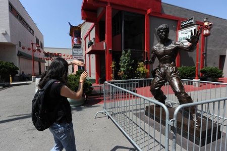 Los Angeles, California, UNITED STATES: A visitor takes a photo of a new statue of the late martial arts icon Bruce Lee is seen in Chinatown in downtown Los Angeles June 16, 2013. The 7.6-feet (2.31 meters) tall bronze statue of the Hollywood legend was unveiled yesterday and will be on temporary display during the summer as organizers work to raise the additional US$150,000 needed to permanently install the statue. AFP PHOTO/Robyn Beck