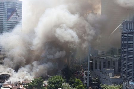 Manila, PHILIPPINES: Smoke rises after a fire engulfed a shanty town in the financial district of Manila on July 11, 2013. There were no immediate reports of casualties from the blaze, which occurred mid-morning amid government plans to relocate thousands of families living in areas vulnerable to floods and typhoons. AFP PHOTO/Karl Malakunas