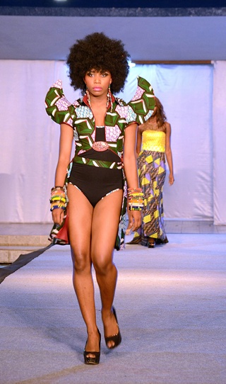 Kinshasa, DEMOCRATIC REPUBLIC OF CONGO: A model parades on the catwalk on July 26, 2013 in Kinshasa, on the first day of the three-day first Fashion Week in Kinshasa. While the army is battling rebels in the Democratic Republic of Congos unstable east, models prepared to sashay down the catwalk at the first Fashion Week in the capital Kinshasa, which has one of the highest murder rates in the world. Gloria Mteyu, 29, told AFP that she had organised the three-day catwalk and fashion exhibition to show that in Congo, there is not just war. AFP PHOTO/Aziz Tutondele