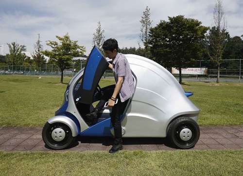 A researcher gets out of Armadillo-T, a foldable electric vehicle, at the Korea Advanced Institute of Science and Technology (KAIST) in Daejeon, south of Seoul September 2, 2013. With a click on a smartphone, the experimental Armadillo-T electric car made in South Korea will park itself and fold nearly in half, freeing up space in crowded cities. The quirky two-seater, named after the animal whose shell it resembles, may never see production but it is part of a trend of developing environmentally friendly vehicles for urban spaces. Picture taken September 2, 2013. REUTERS/Kim Hong-Ji 