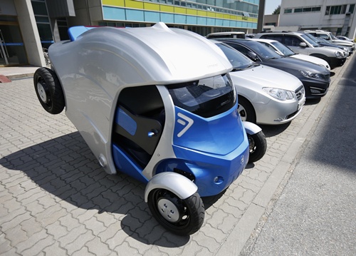 Armadillo-T, a foldable electric vehicle, folds up its rear at the Korea Advanced Institute of Science and Technology (KAIST) in Daejeon, south of Seoul September 2, 2013. With a click on a smartphone, the experimental Armadillo-T electric car made in South Korea will park itself and fold nearly in half, freeing up space in crowded cities. The quirky two-seater, named after the animal whose shell it resembles, may never see production but it is part of a trend of developing environmentally friendly vehicles for urban spaces. Picture taken September 2, 2013. REUTERS/Kim Hong-Ji 
