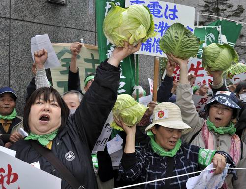 เกษตรกรญี่ปุ่นจากจังหวัดฟูกูชิมะไปชุมนุมประท้วงที่หน้าสำนักงานใหญ่ของบริษัทเท็ปโก ผู้บริหารโรงไฟฟ้าฟูกูชิมะไดอิจิ เมื่อวันที่ 26 เมษายน ปี 2011 หลังเกิดกระแสหวาดกลัวกัมมันตภาพรังสีจนทำให้พืชผลของพวกเขาขายไม่ออก (แฟ้มภาพ) 