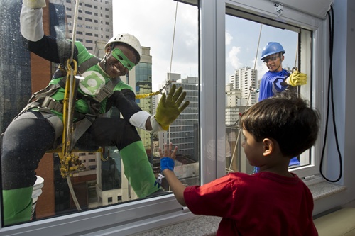 Sao Paulo, Sao Paulo, BRAZIL: Window cleaners wearing superhero costumes greet a patient at a Childrens Hospital, as part of the celebration of Childrens Day in Sao Paulo, Brazil on October 10, 2013. Childrens Day is celebrated in Brazil on October 12. AFP PHOTO/Nelson Almeida