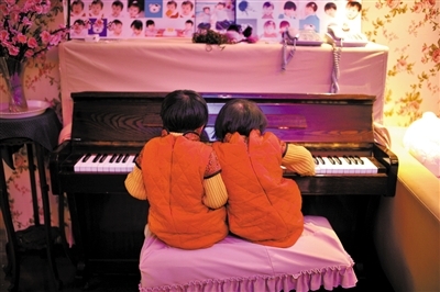สองพี่น้องฝาแฝดเล่นเปียโน เมื่อเดือน ธ.ค. 2556 (ภาพเฟิงหวง) 