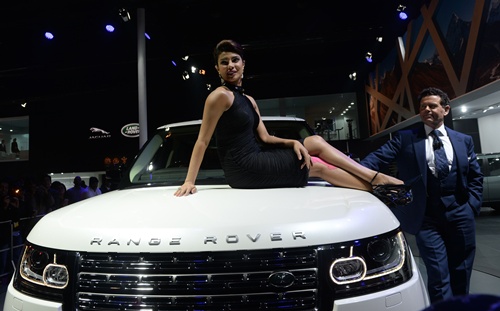 New Delhi, INDIA: Indian Bollywood actress Priyanka Chopra (C) poses on the bonnet of a Range Rover LWB AUTOBIOGRAPHY BLACK after the launch ceremony at the 12th Auto Expo in Greater Noida on the outskirts of New Delhi on February 5, 2014 .AFP PHOTO/Sajjad Hussain 