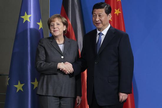 นางอังเกลา แมร์เคิล นายกรัฐมนตรีเยอรมนี(ซ้าย) จับมือให้การต้อนรับแขกผู้มาเยือนประนาธิบดีสี จิ้นผิงของจีน