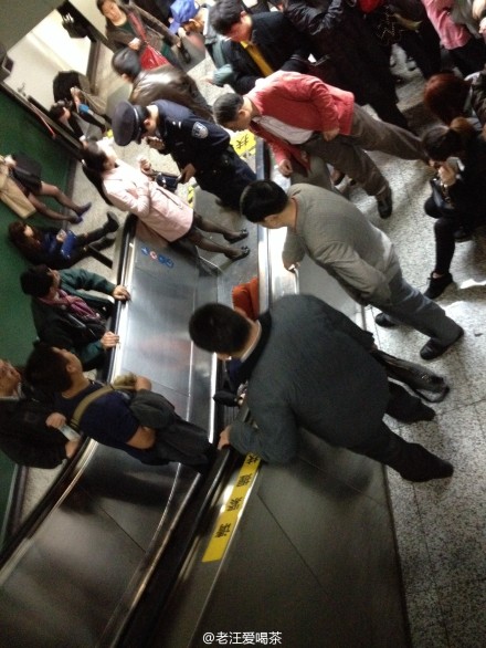 ผู้คนต่างชุลมุนอยู่รอบๆ ผู้บาดเจ็บรายหนึ่งที่นอนอยู่ท้ายบันไดเลื่อนของสถานีรถไฟใต้ดินในเซี่ยงไฮ้ (ภาพ เวยปั๋ว)