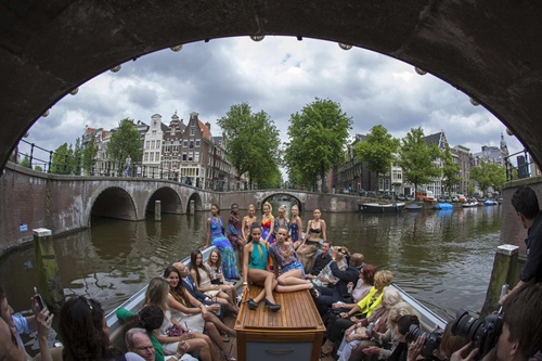 Models Sammy Jo Manbodh and Selina Sandberg (C) present swimwear by Gottex on a boat at the Canal Catwalk for the opening of the World Fashion Festival in Amsterdam May 21, 2014. REUTERS/Cris Toala Olivares