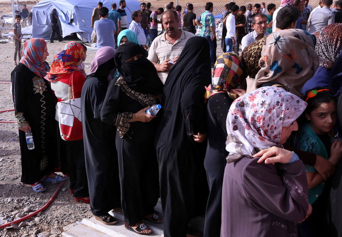 ครอบครัวชาวอิรักที่หลบหนีเหตุรุนแรงในจังหวัดนิเนเวห์ กำลังรอข้ามพรมแดนไปยังเขตปกครองตนเองเคอร์ดิสถาน