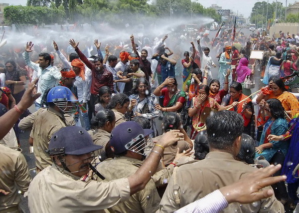 (ภาพจากแฟ้ม) เจ้าหน้าที่ตำรวจอินเดียฉีดน้ำแรงดันสูงเพื่อสลายกลุ่มผู้สนับสนุนพรรคภารติยะชนตะที่ร้องตะโกนต่อต้าน และพยายามจะบุกเข้าไปในที่ทำการของ อัคคีเลช ยาดาฟ มุขมนตรีของรัฐอุตตรประเทศ ภายหลังที่มีเด็กสาว 2 คนถูกรุมโทรมและแขวนคอในรัฐนี้ (2 มิ.ย.)