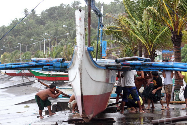ชาวบ้านในเมืองเลกัซปีต่างช่วยกันผูกเรือประมง ก่อนที่ไต้ฝุ่นรามสูรจะพัดขึ้นฝั่งในช่วงค่ำวันนี้(15)