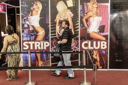MIdrand, SOUTH AFRICA: A South African couple arrives at a strip club parlour at the 2014 edition of the Sexpo in Midrand on September 25, 2014. The health, sexuality and lifestyle expo attracting thousands of visitors every year started today in South Africa. AFP PHOTO/Marco Longari