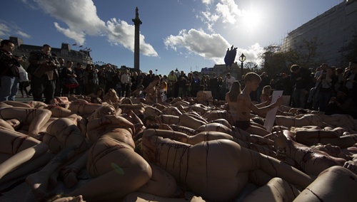 London, Greater London, UNITED KINGDOM: Around 100 people lie naked or partially clothed on the floor in Trafalgar Square covered in fake blood as part of a PETA protest against the meat and fishing industry and to make people aware of World Vegan Day in London on November 1, 2014. AFP PHOTO/Andrew Cowie