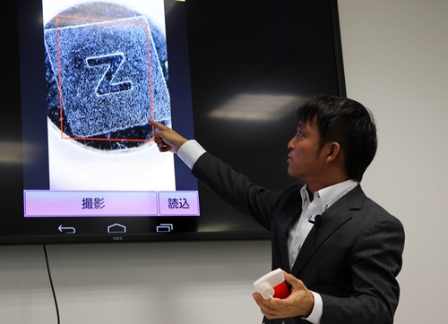Tokyo, Tokyo, JAPAN: Japans computer giant NEC employee displays fake products detecting system using a smartphone in Tokyo on Novemner 10, 2014. The system makes an analysis of surface patterns of the metal products such as head of the screws with users smartphones to detect piracy products. AFP PHOTO/Yoshikazu Tsuno