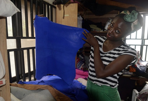 Lagos, NIGERIA: Handbag designer Zainab Ashadu, 32, shows high-quality leather on July 17, 2014 at her Lagos workshop. The Nigerian designer is the brains behind the Zashadu brand, whose modern, colourful creations use the ancient art of tanning and leather-dyeing from the countrys north. The leather comes from the norths biggest city, Kano, goatskin from the ancient northwestern city of Sokoto as well as python skin from snake farms in the region. AFP PHOTO/Pius Utomi Ekpei