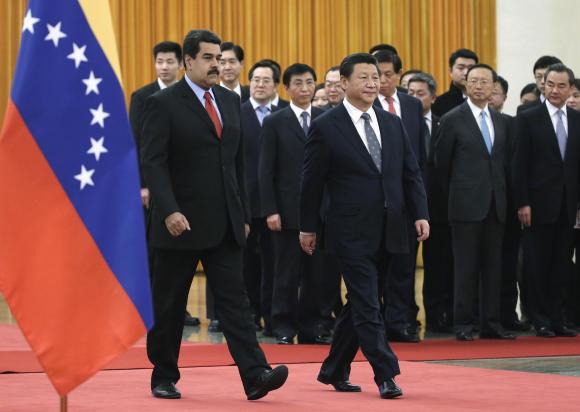 ประธานาธิบดี นิโคลัส มาดูโร แห่งเวเนซูเอลา (ซ้าย) เดินมากับประธานาธิบดี สี จิ้นผิง ของจีน (ขวา) ขณะทั้งคู่เข้ามาถึงพิธีต้อนรับที่มหาศาลาประชาชนในกรุงปักกิ่ง เมื่อวันที่ 7 มกราคม ปี 2015