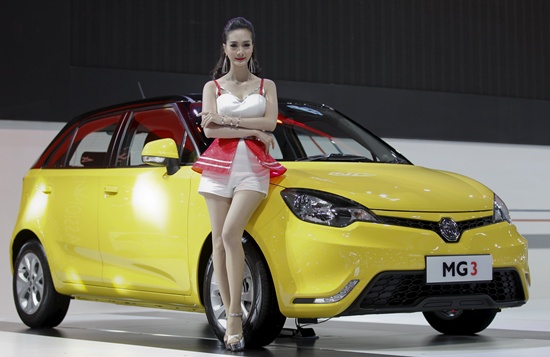 A model poses beside a MG3 during a media presentation of the 36th Bangkok International Motor Show in Bangkok March 24, 2015. The Bangkok International Motor Show will be held from March 25 to April 5. REUTERS/Chaiwat Subprasom