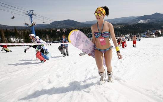 A woman in a bikini walks up to the start position of a downhill ski and snowboard descent in swimwear event on Mount Zelyonaya (The Green Mount), at a ski resort near the town of Sheregesh in the Siberian Kemerovo region April 18, 2015. REUTERS/Ilya Naymushin