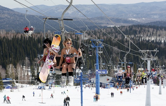 Women ride a lift during a downhill ski and snowboard descent in swimwear event on Mount Zelyonaya (The Green Mount), at a ski resort near the town of Sheregesh in the Siberian Kemerovo region April 18, 2015.  REUTERS/Ilya Naymushin