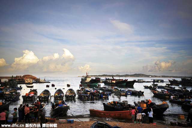 <span style=color: #993300;><strong>ขึ้นฝั่ง</strong></span> - คนหาปลาทอดสมอเรือเพื่อขึ้นฝั่งมาค้าขายปลา ที่ซานเว่ย มณฑลกว่างตง (ภาพไอซี)