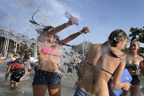 Lausanne, Vaud, SWITZERLAND: Ravellers throw water during a giant water battle against the heatwave event on July 3, 2015 in Lausanne as a blistering heatwave sweeps through Europe. AFP PHOTO/Fabrice Coffrini