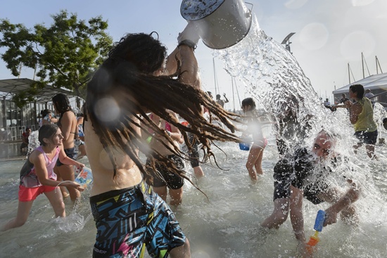 Lausanne, Vaud, SWITZERLAND: Ravellers throw water during a giant water battle against the heatwave event on July 3, 2015 in Lausanne as a blistering heatwave sweeps through Europe. AFP PHOTO/Fabrice Coffrini