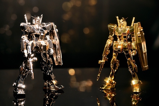 Tokyo, Tokyo, JAPAN: Japans jeweler Tanaka Kikinzoku Jewelry displays a pure gold robot figure Gundam, standing 12.5cms tall, weighing one kilogram and with a price of US$160,000 (20 million yen) and a pure platinum made Gundam figure, 12.5cms tall, weighing one kilogram, owned by Japanese toy maker Bandai and not for sale, at a press preview of The Art of Gundam exhibition in Tokyo on July 17 2015. AFP PHOTO/Yoshikazu Tsuno