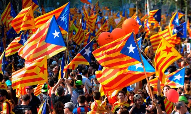 ชาวคาตาลันที่สนับสนุนการแยกตัวเป็นเอกราชจากสเปนโบกสะบัดผืนธงคาตาโลเนีย