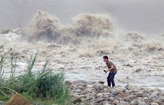 NEW TAIPEI CITY, TAIWAN: A local resident collects stones from the Xindian river after Typhoon Dujuan passed in the New Taipei City on September 29, 2015. Super typhoon Dujuan killed two and left more than 300 injured in Taiwan before making landfall in China. AFP PHOTO/Sam Yeh