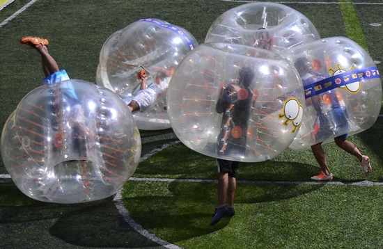 Medellin, ANTIOQUIA, COLOMBIA: People wearing plastic made bubble balls, enjoy a five-on-five game of bubble-soccer in Medellin, Antioquia department, Colombia on October 10, 2015. AFP PHOTO/Raul Arboleda