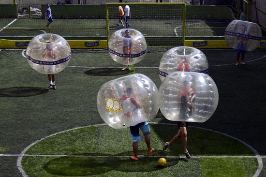 Medellin, ANTIOQUIA, COLOMBIA: People wearing plastic made bubble balls, enjoy a five-on-five game of bubble-soccer in Medellin, Antioquia department, Colombia on October 10, 2015. AFP PHOTO/Raul Arboleda