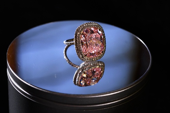 Geneva, Geneve, SWITZERLAND: This photo taken on on October 30, 2015 in Geneva shows a 16.08-carat pink diamond on display during a press preview by the auction house Christies. The large cushion-shaped pink diamond set in a ring is expected to fetch between US$23 - 28 million in the forthcoming Magnificent Jewels auction on November 10, 2015 in Geneva. AFP PHOTO/Fabrice Coffrini