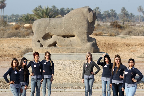 hilla, IRAQ: Some Iraqi candidates for Miss Iraq beauty contest pose in front of a basalt statue of a lion at the ancient archaeological site of Babylon, outside the modern city of Hilla, south of the capital Baghdad on December 17, 2015. AFP PHOTO/Ahmad Al-Rubaye