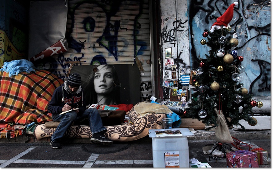 คริสโตส (Christos) ชายเร่ร่อนบนถนนในกลางกรุงเอเธนส์ กรีซ กำลังเขียนกลอนใกล้กับต้นคริสต์มาส